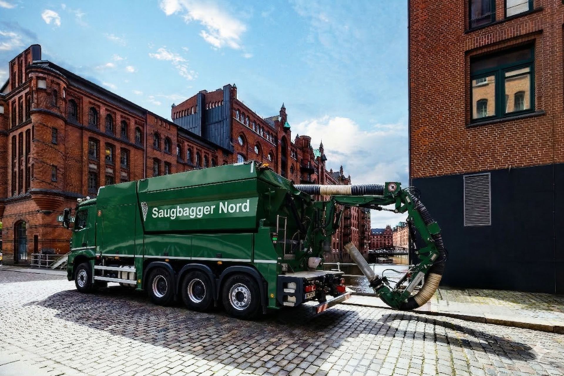 Saugbagger auf Lkw-Fahrgestell auf Kopfsteinpflaster, Saugarm seitlich ausgeschwenkt